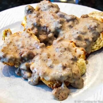 biscuit and sausage gravy on a white plate