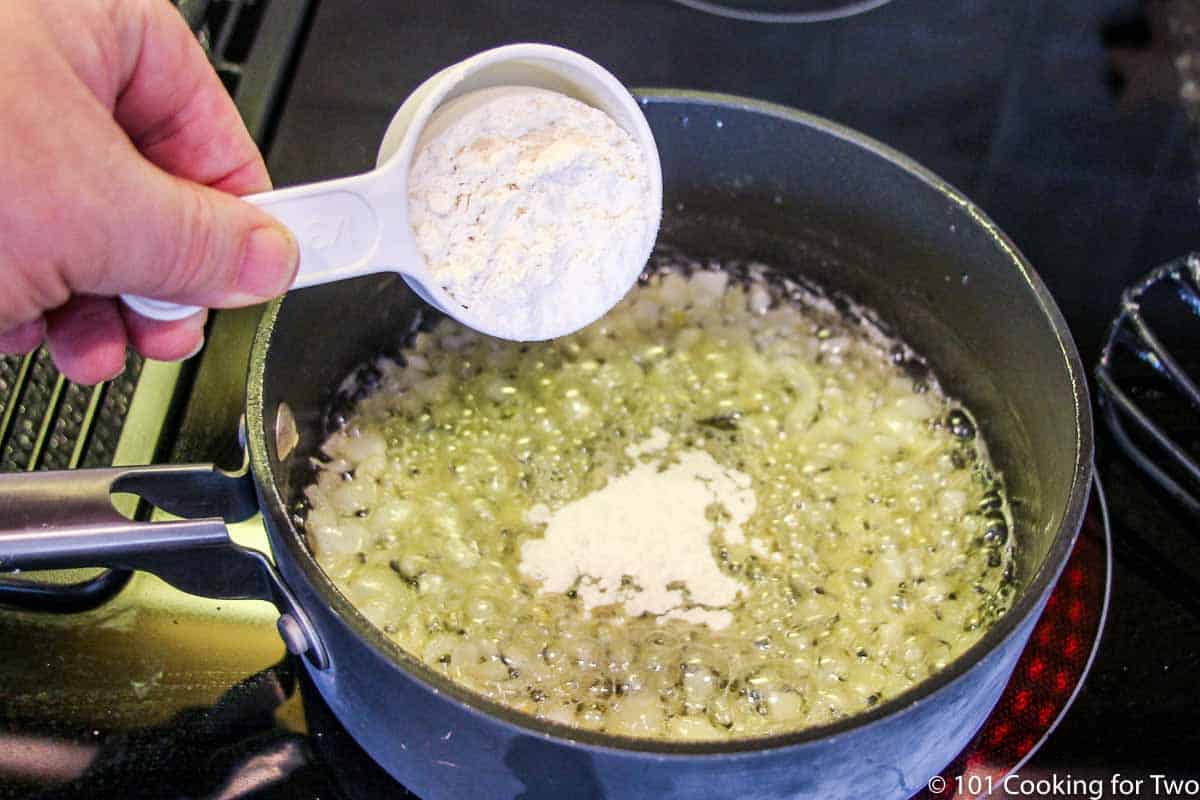 adding flour to saucepan with butter and onion