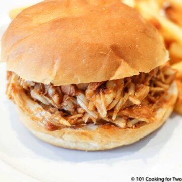 a shredded BBQ chicken sandwich on a white plate