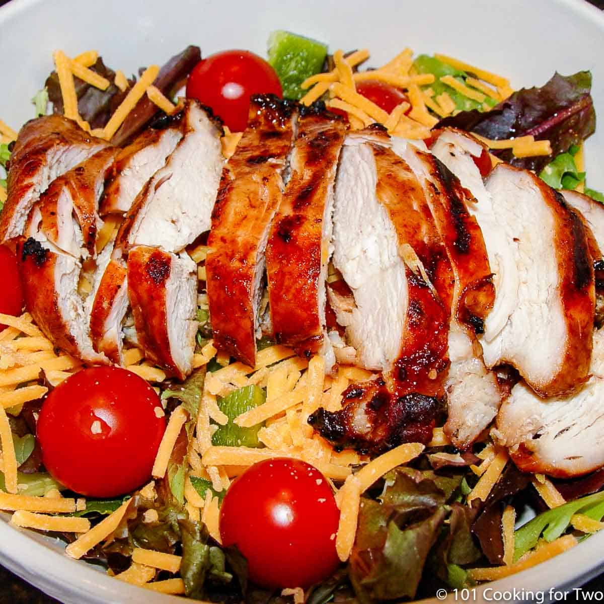 Cut marinaded chicken breast in a green salad.