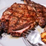 cut ribeye steak on white plate