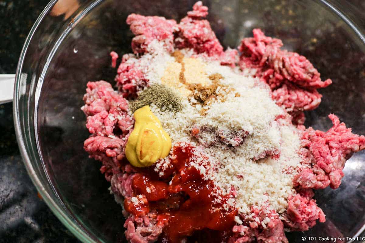 raw burger with bread crumbs and mustard in bowl