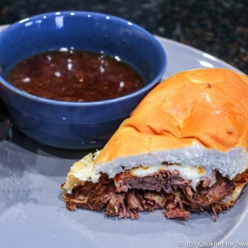 image of a French dip sandwich with dip on a gray plate.