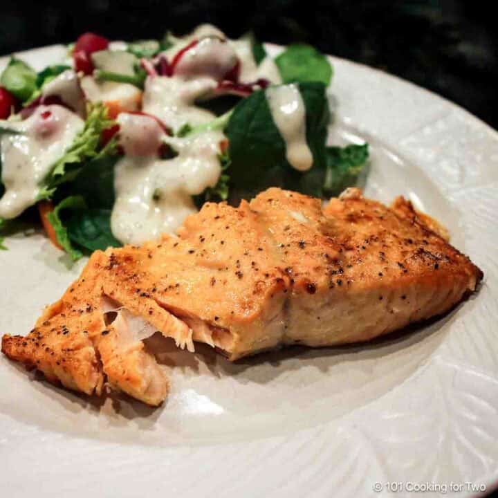 closeup image of salmon flaking on a light gray plate