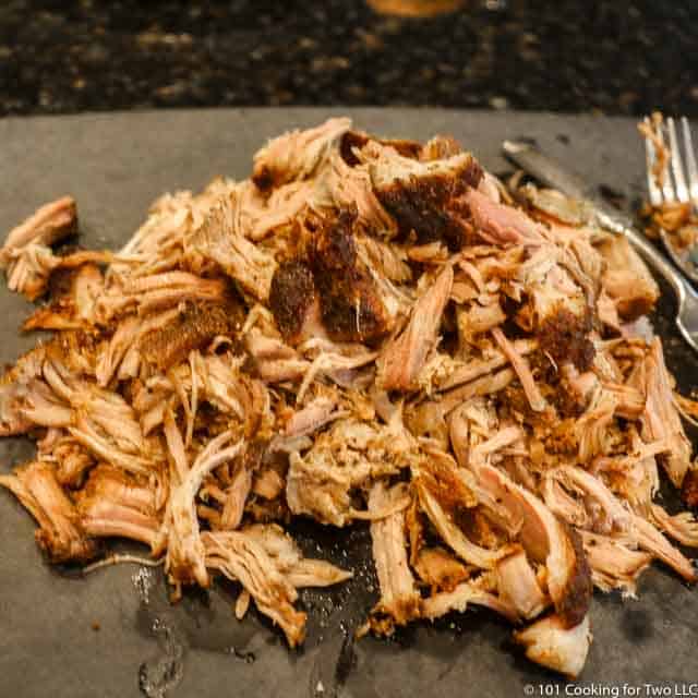 image of a pile of pulled pork on a black cutting board