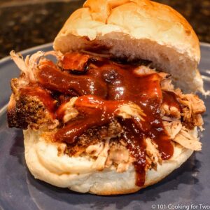 Pulled pork with sauce in a bun on a blue plate