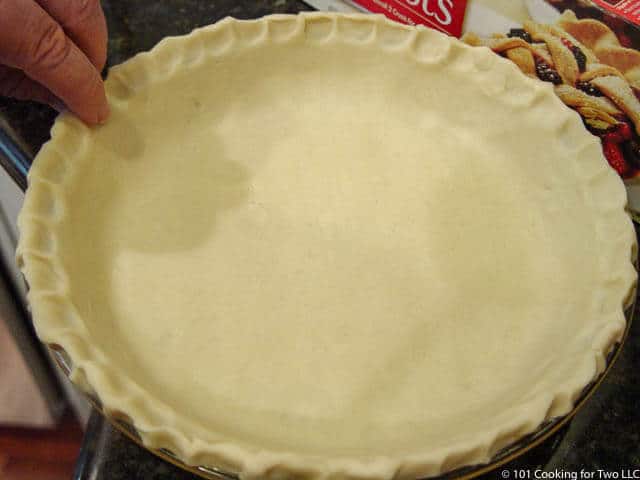 image of crimping the edge of the pie crust before baking