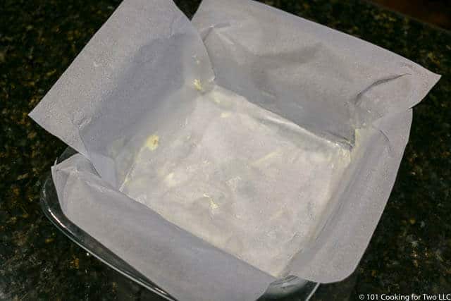 image of a 9 by 9 baking dish lined with parchment paper
