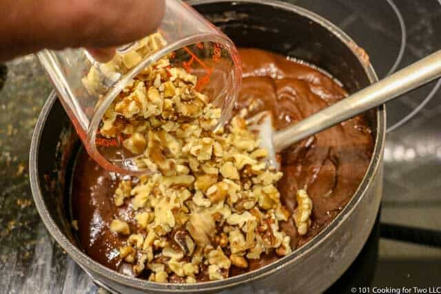 image of adding chopped nuts to the fudge in the black pan