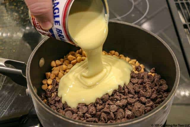 image of adding sweetened condenced milk to a black non-stick pan with the chips