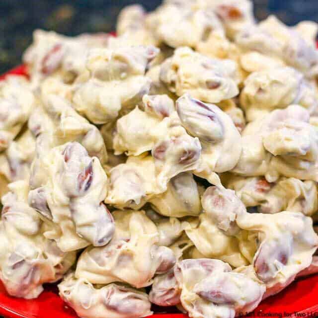 image of a pile of white chocolate almond clusters on a red plate