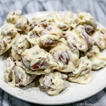 white chocolate almond clusters on a white plate
