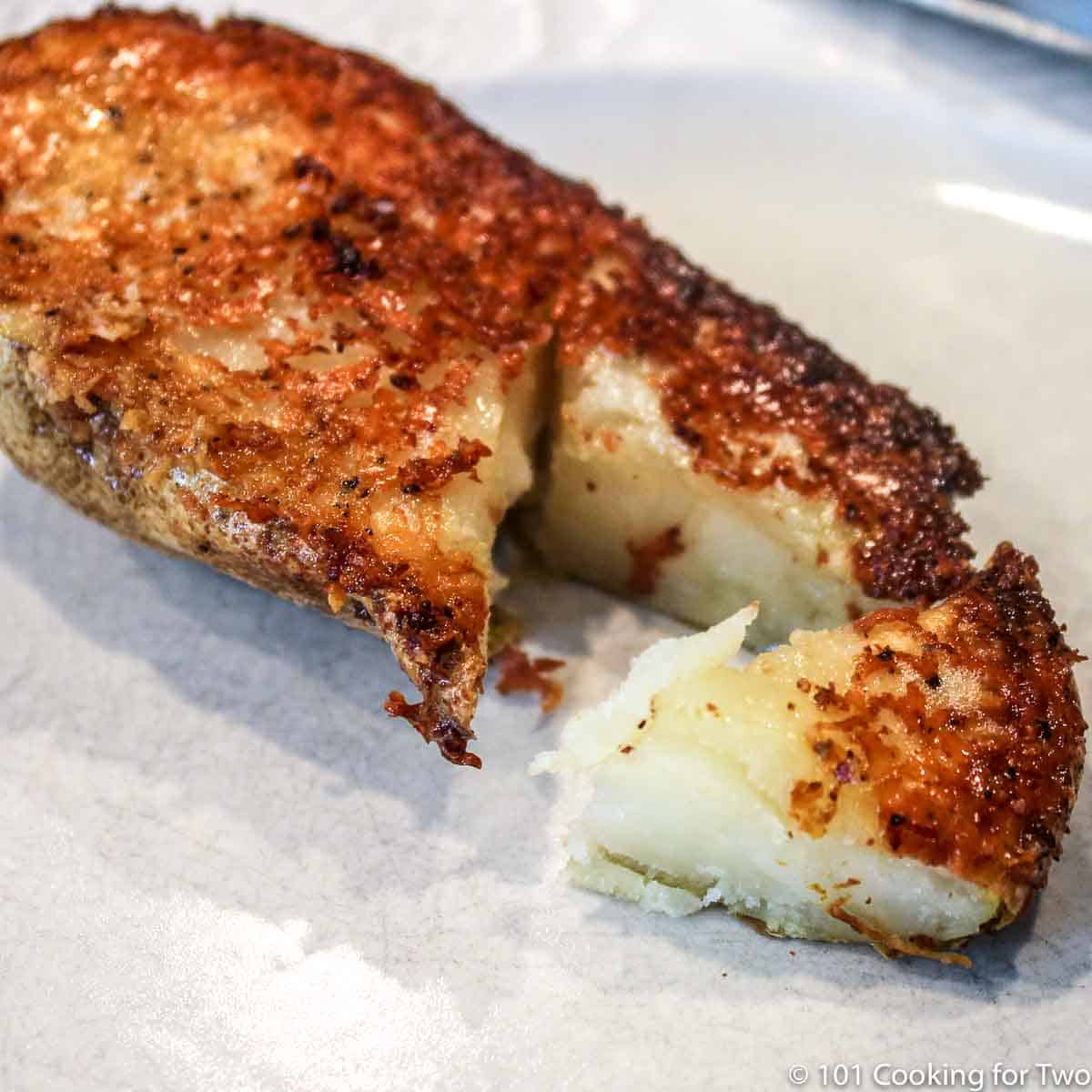 parmesan baked potato on a white plate.