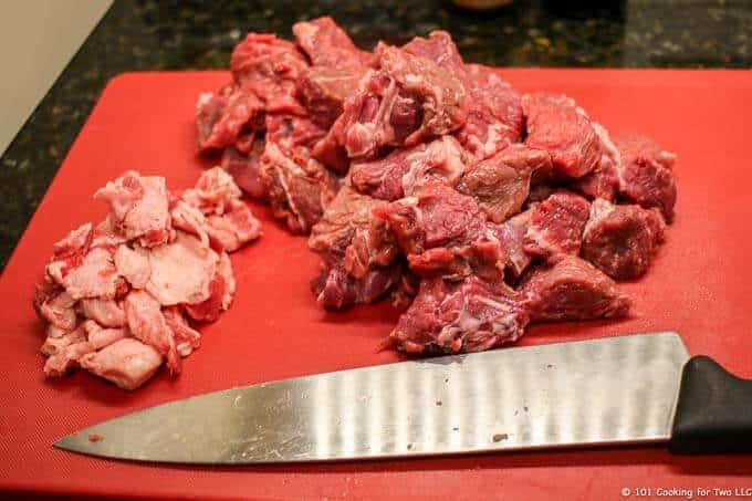 image of cutting up a chuck roast on a red cutting board
