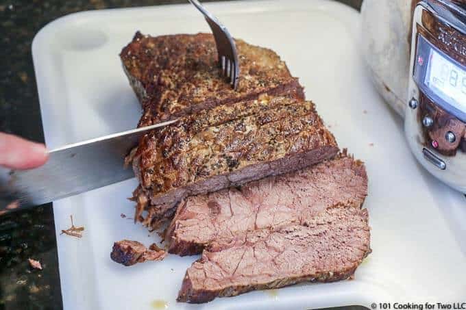 cutting beef roast on a white board