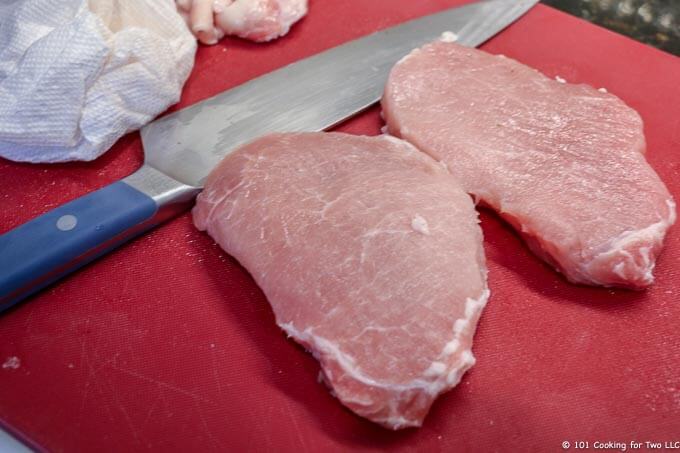 image of pork chops trimmed on red cutting board