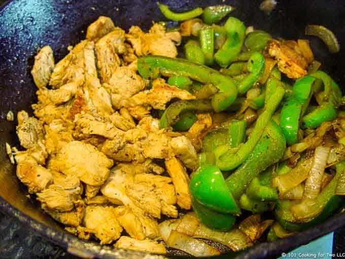 image of cooked chicken and pepper in a black skillet