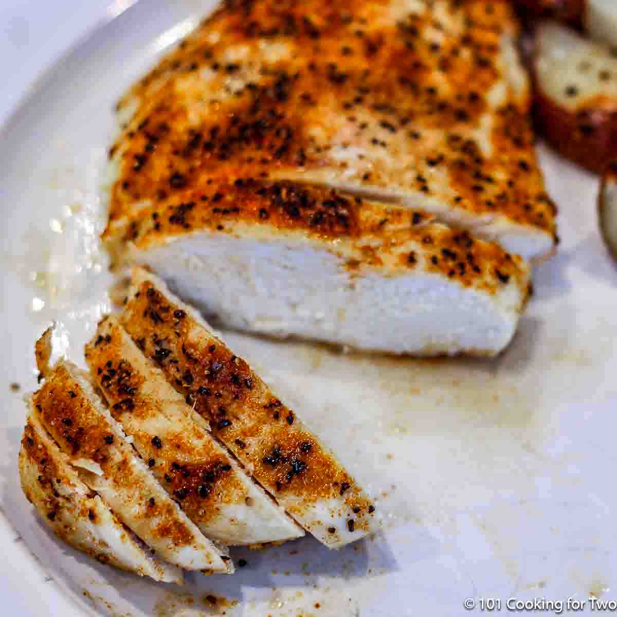 image of cut baked chicken on white plate