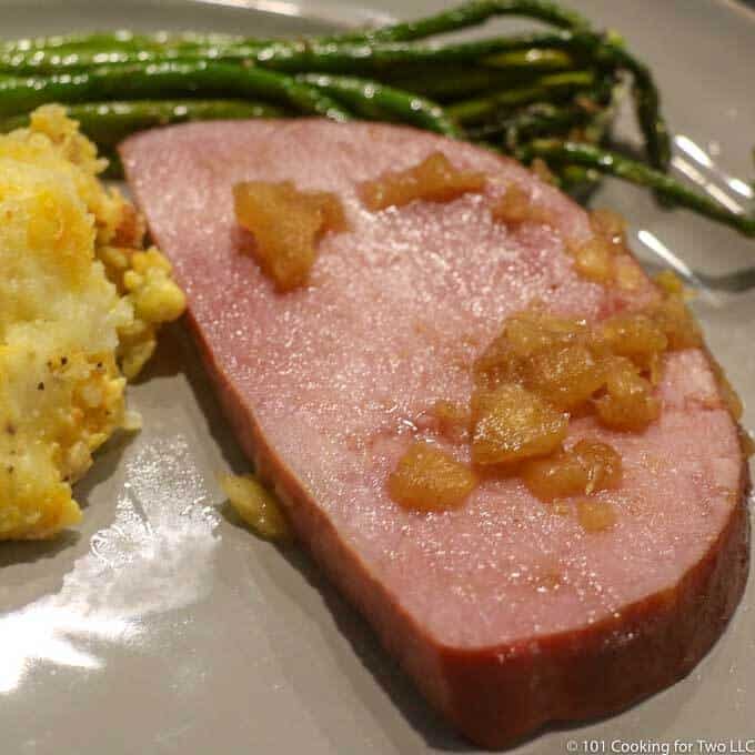 image of cut ham with pineapple on gray plate
