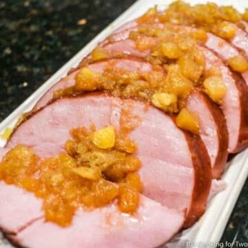 Cut ham with pineapple honey glaze on a white plate