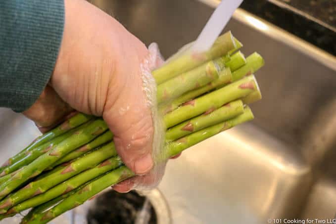 image of washing asparagus under running water