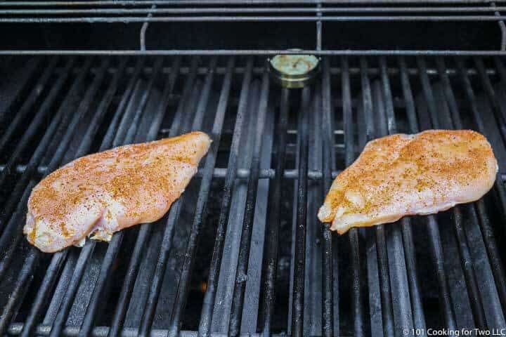 two chicken breasts on a gas grill
