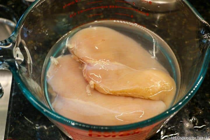 chicken breasts in a bowl of brine