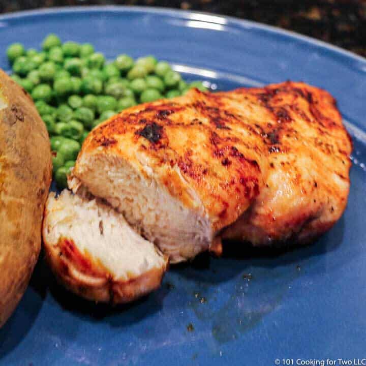 cut grilled chicken breasts on blue plate