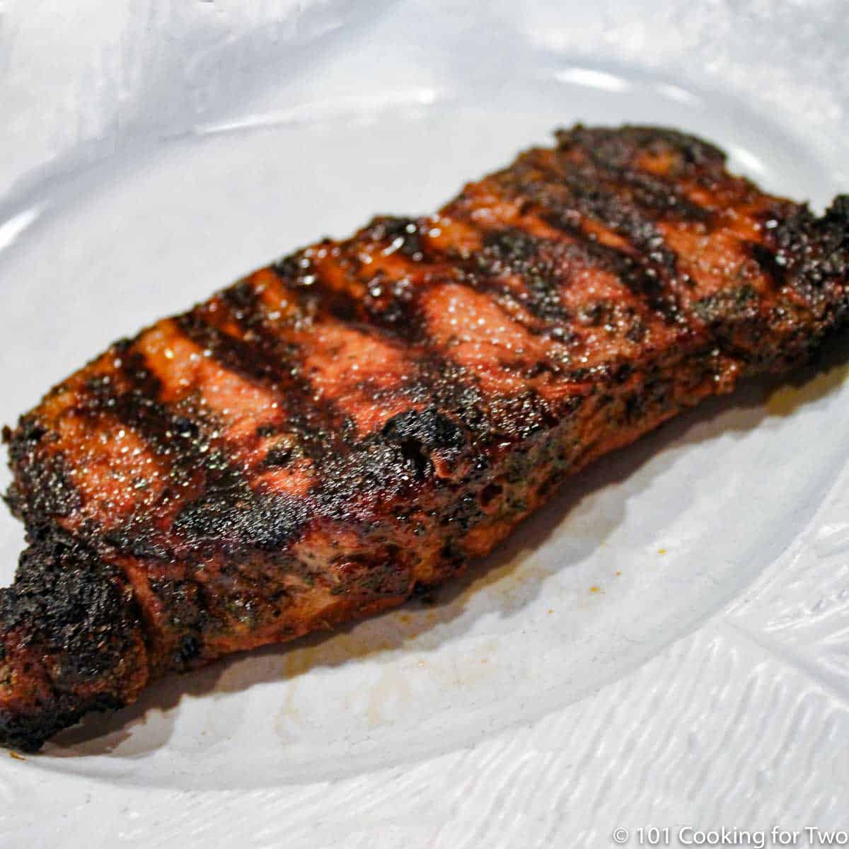 grilled marinaded strip steak ona white plate.