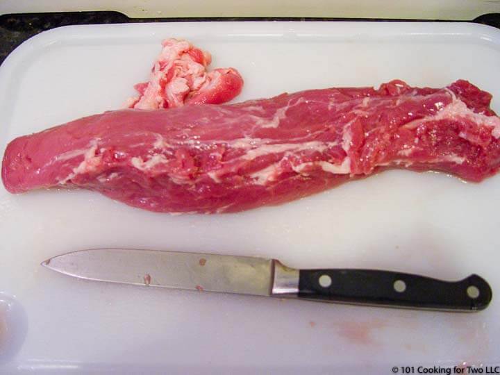 trimmed pork tenderloin on a white board