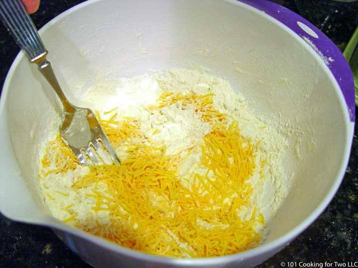 mixing shredded cheese into dry mix