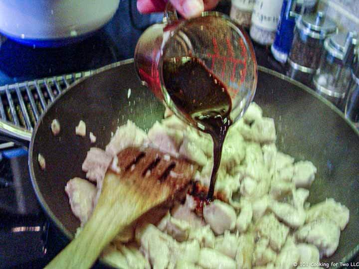 adding sauce to cooked chicken