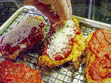 adding cheese topping to chicken with sauce
