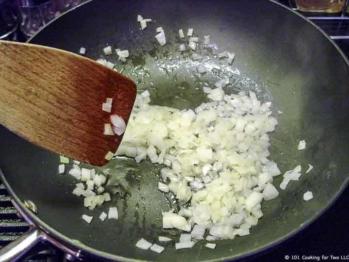 cooking onion in black skillet.