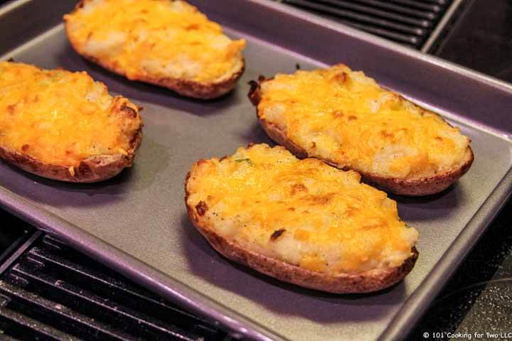 four potatoes browned on baking tray.