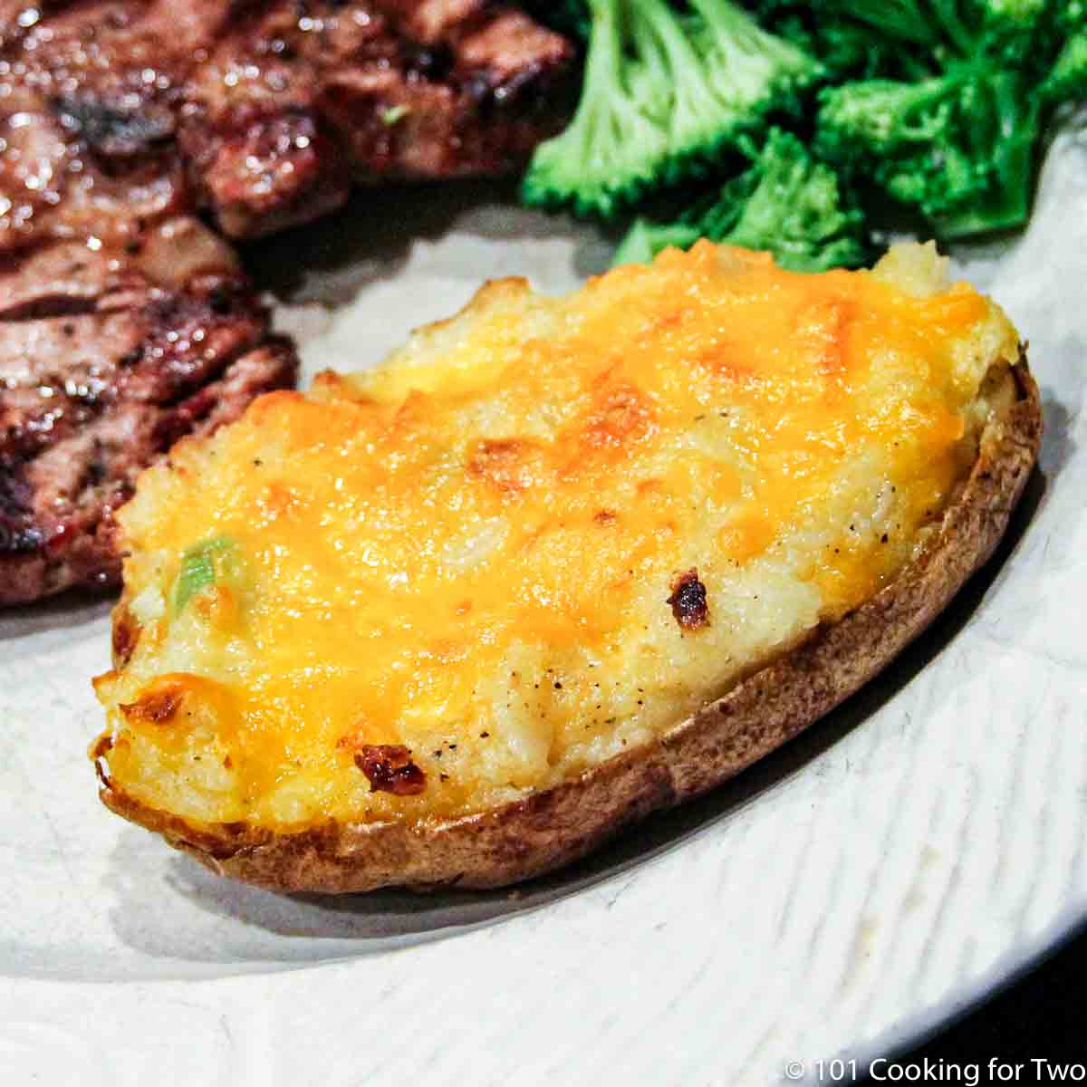 twice baked potato on white plate with meal.