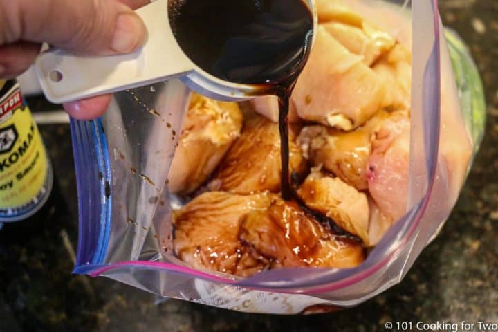 adding soy sauce to bag with chicken