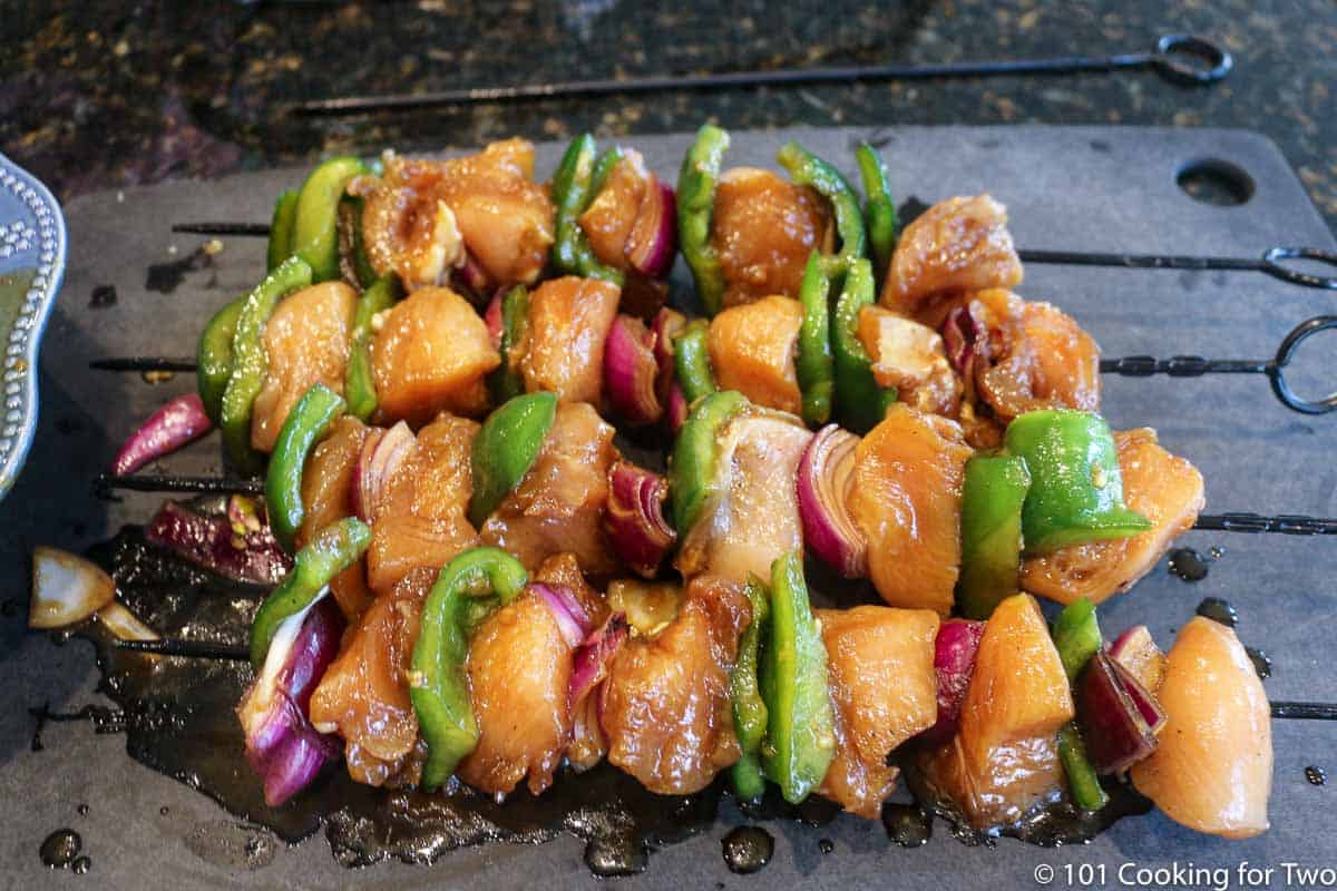 assembled kabobs ready on black board.