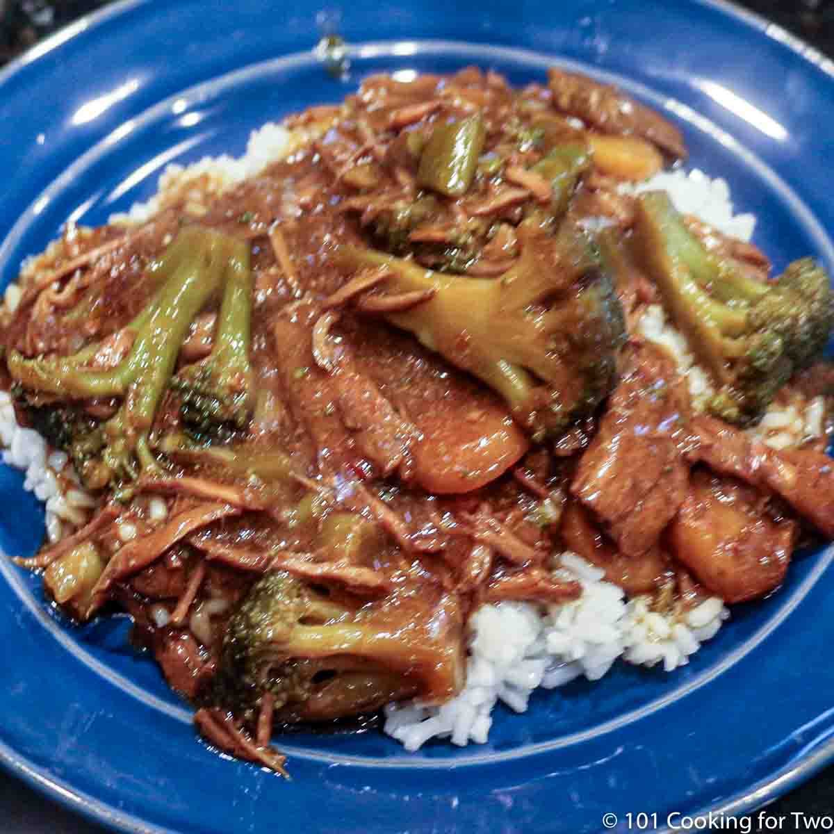beef and broccoli with rice on blue plate.