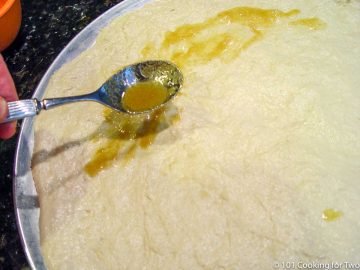 coating the dough with butter and garlic