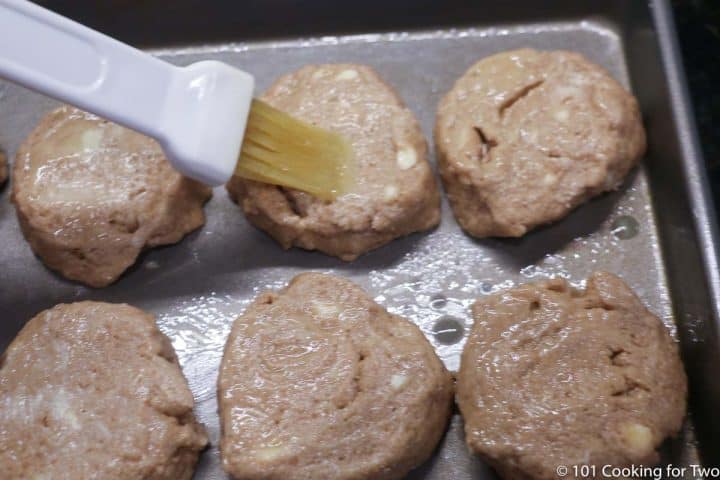 brushing butter on biscuits