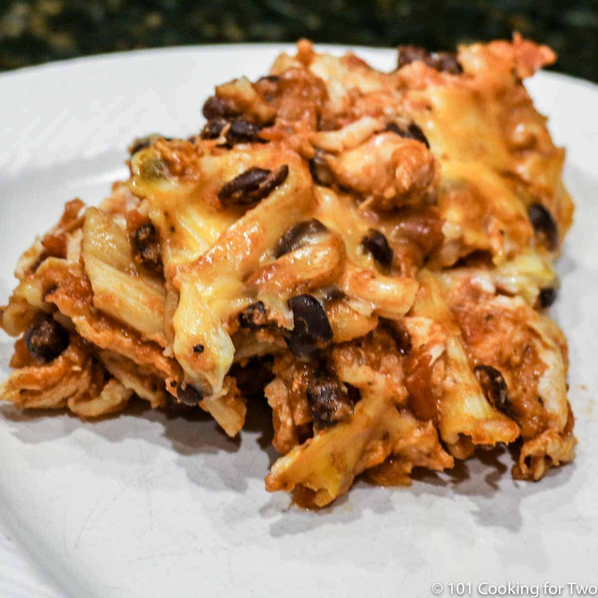 cheesy chicken casserole on a white plate.