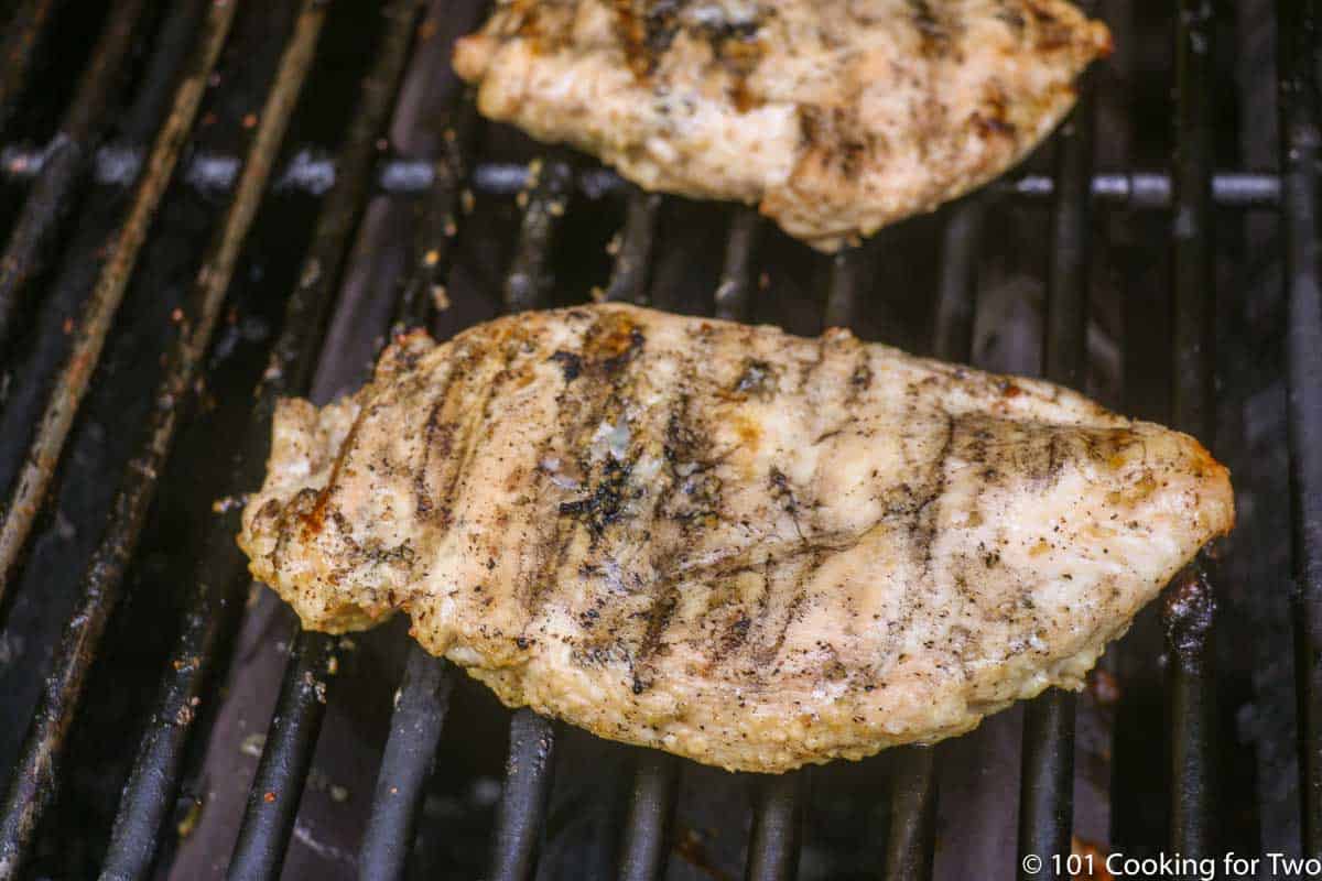 chicken breasts with grill marks starting to cook on grill