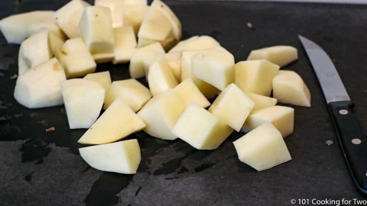 cut up raw potatoes on black board