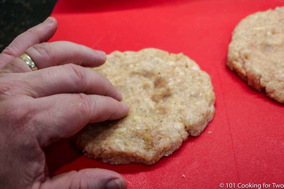 dimpling the center of a chicken patty.