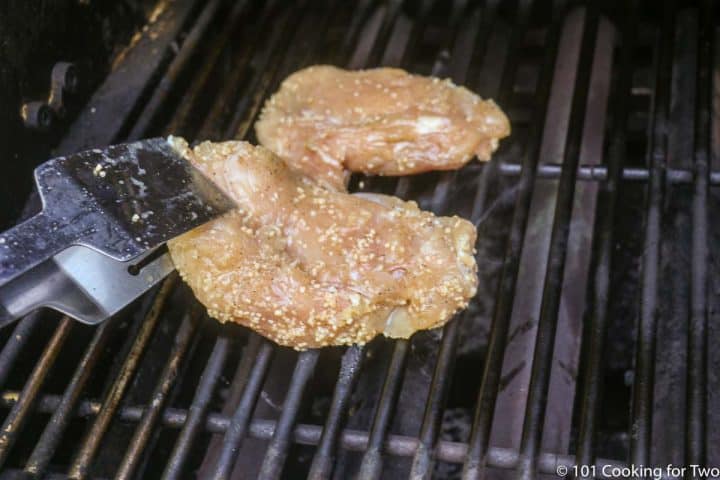 marinaded chicken going on grill grates