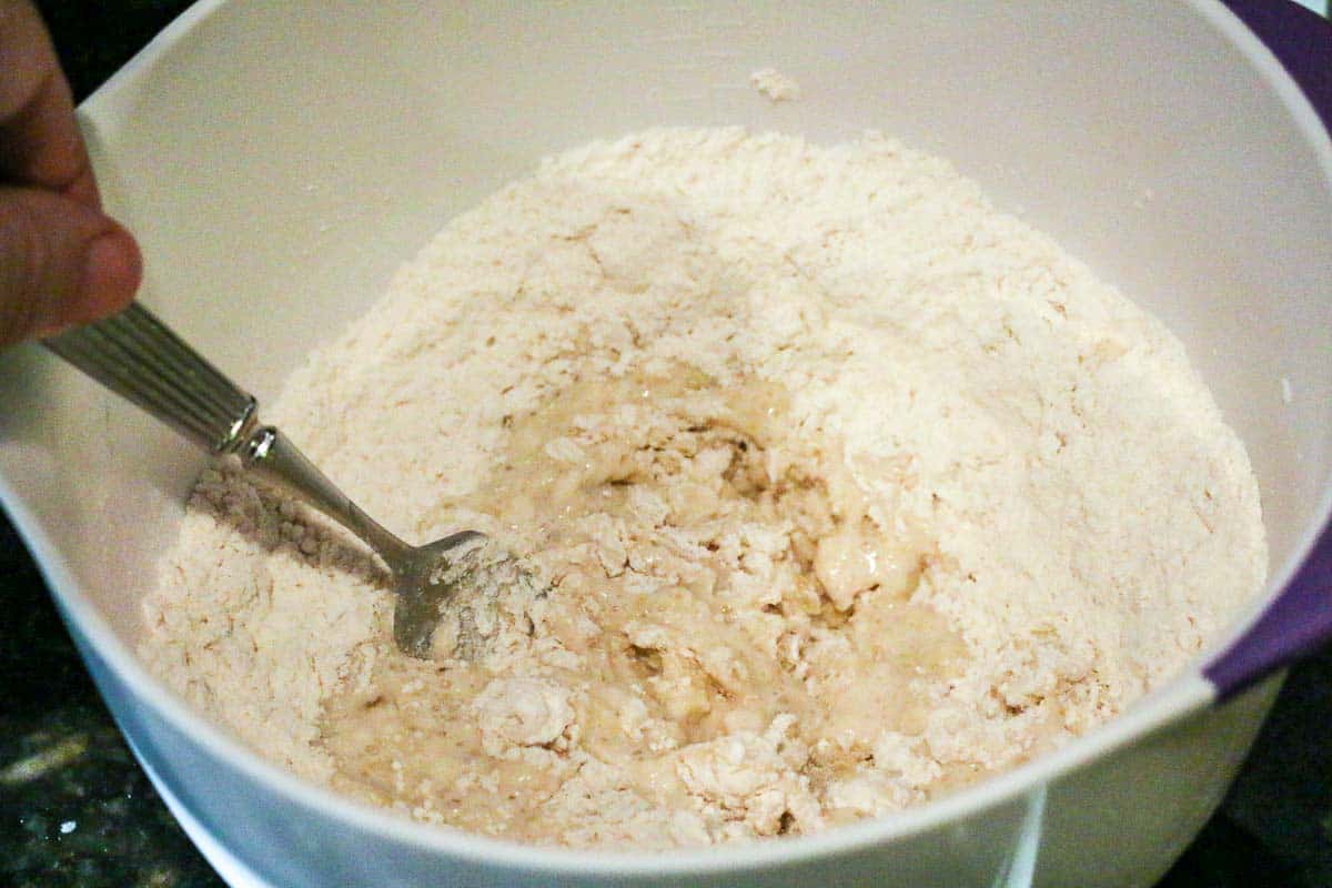 mixing dough in white bowl with a fork