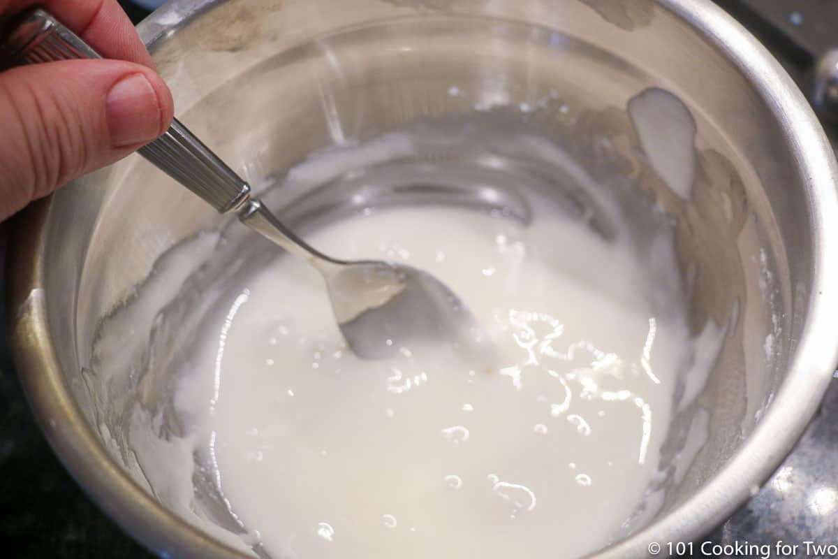 mixing frosting in metal bowl.