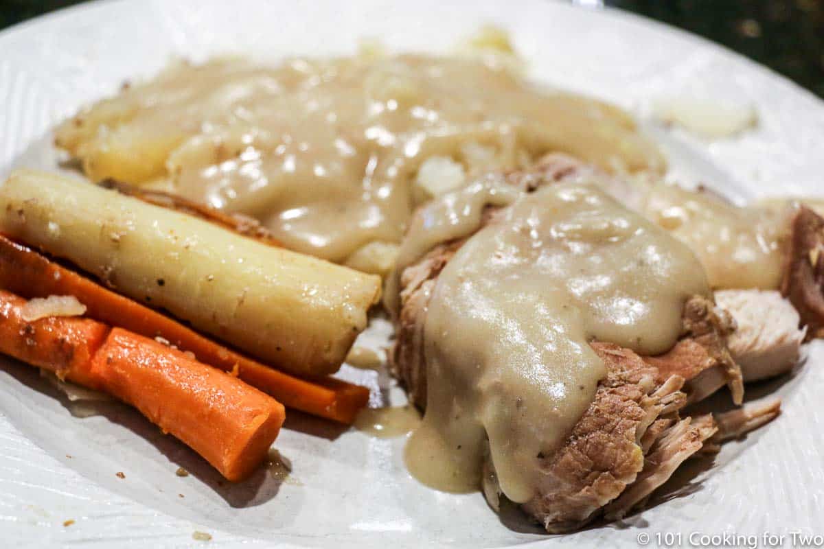 pork loin roast with gravy on plate.