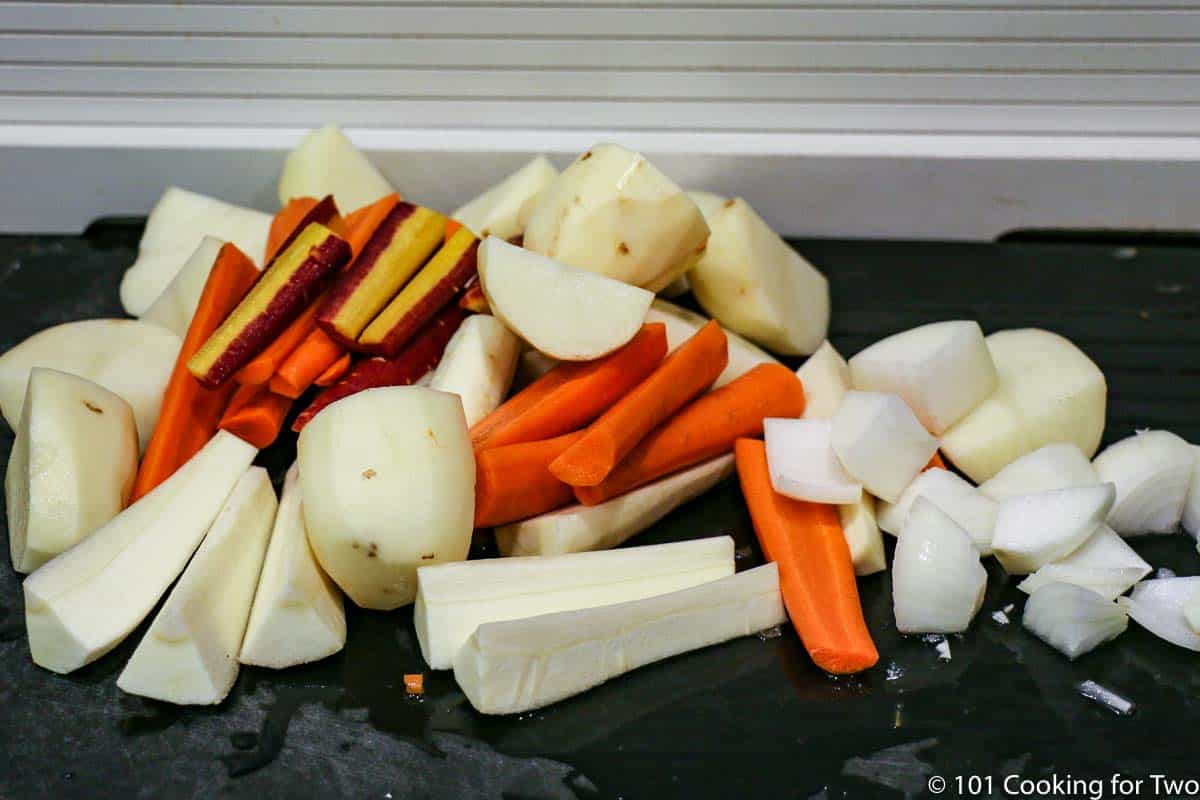 root vegetables cut up on black board.